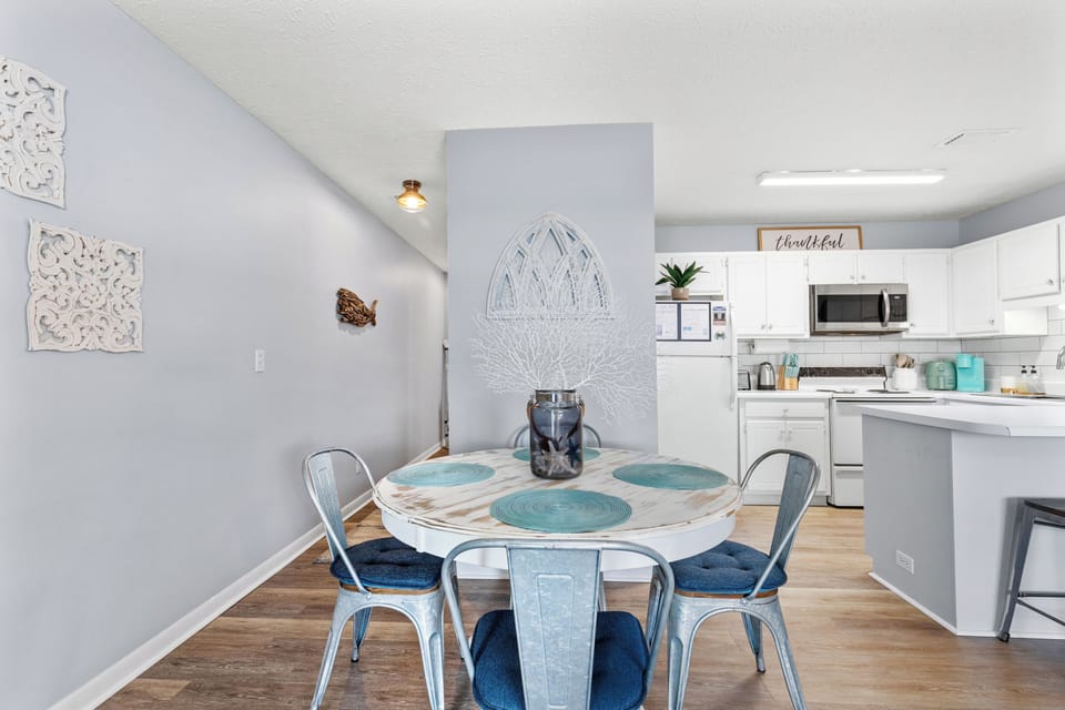 Enjoy meals in the stylish dining space with a cozy beach themed round table