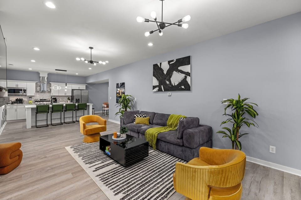 Living room  with cozy couch; nearby the kitchen area