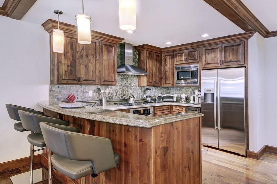 The gourmet kitchen showcases rich wooden cabinetry and contemporary appliances, offering both style and functionality for culinary enthusiasts.