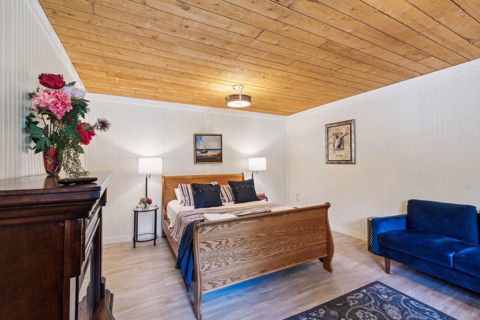 Upon entering, the primary bedroom will greet you. It's spacious with a queen bed and fireplace.