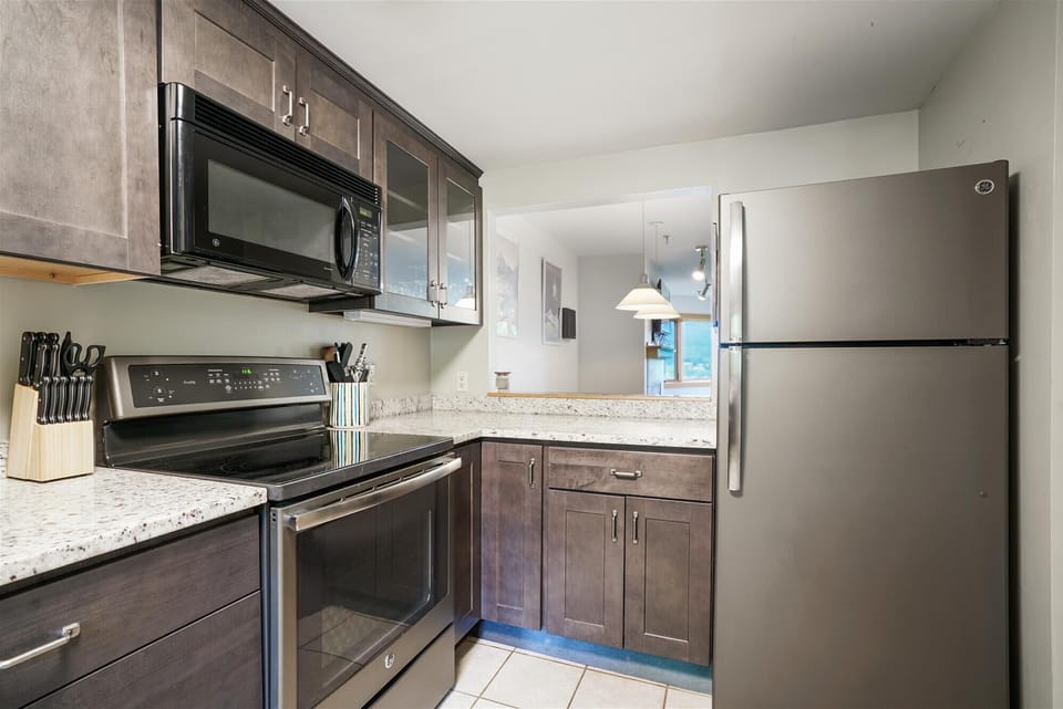 Updated kitchen featuring stainless appliances, granite counters, and everything needed for easy vacation meals.