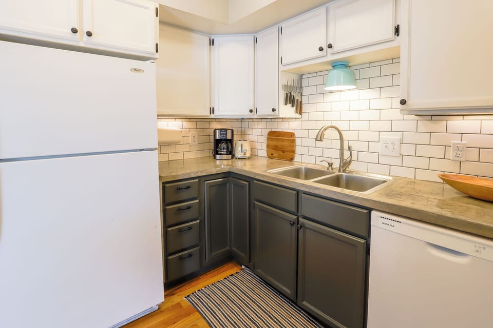 Dishwasher/refrigerator/coffee maker/lots of fully stocked cupboards in kitchen.