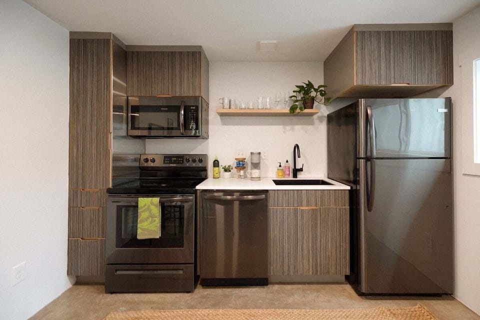 Cook with ease in a sleek kitchen stocked with essentials, a Keurig coffee maker, and a selection of coffee and creamer.