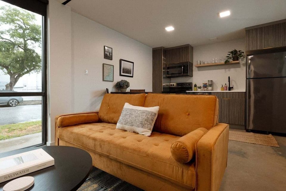 Relax downstairs in a bright, thoughtfully designed living space featuring comfortable seating, a Smart TV for streaming, and fast 500mbs AT&T Fiber Wi-Fi