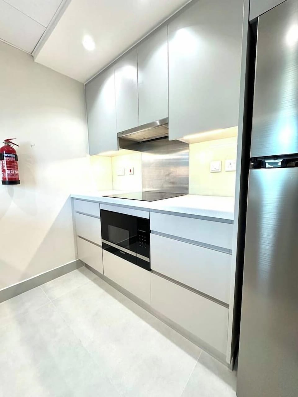 Modern 1-bedroom vacation rental in Burj Views Tower B, Downtown Dubai. Features a sleek, fully-equipped kitchen with stainless steel appliances and contemporary cabinetry. Ideal holiday home for short-term and in Dubai's bustling Downtown area.