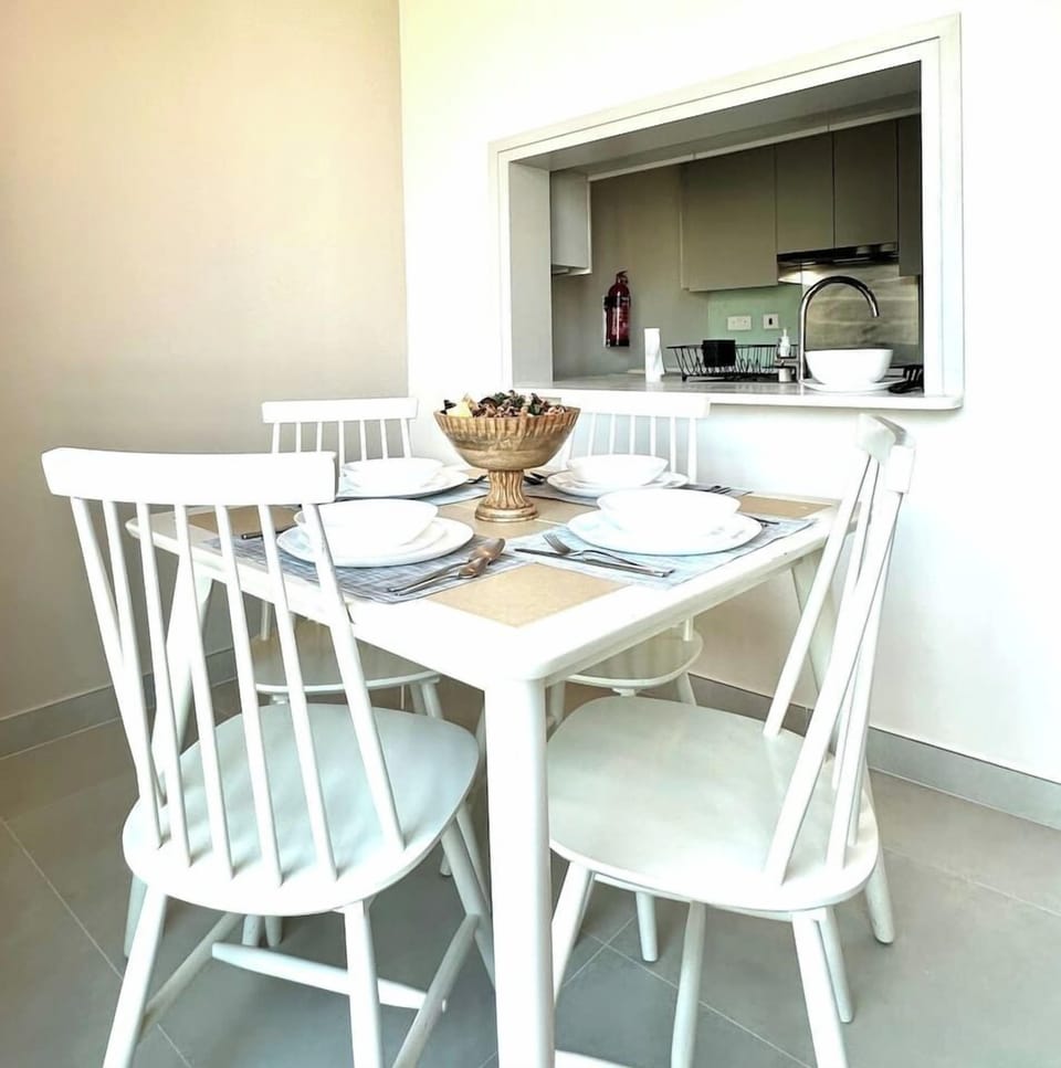 Charming 1-bedroom vacation rental in Burj Views Tower B, Downtown Dubai. Features a cozy dining area with a pass-through window to a modern kitchen, perfect for holiday stays. Ideal short-term in the heart of Dubai's bustling Downtown neighborhood.