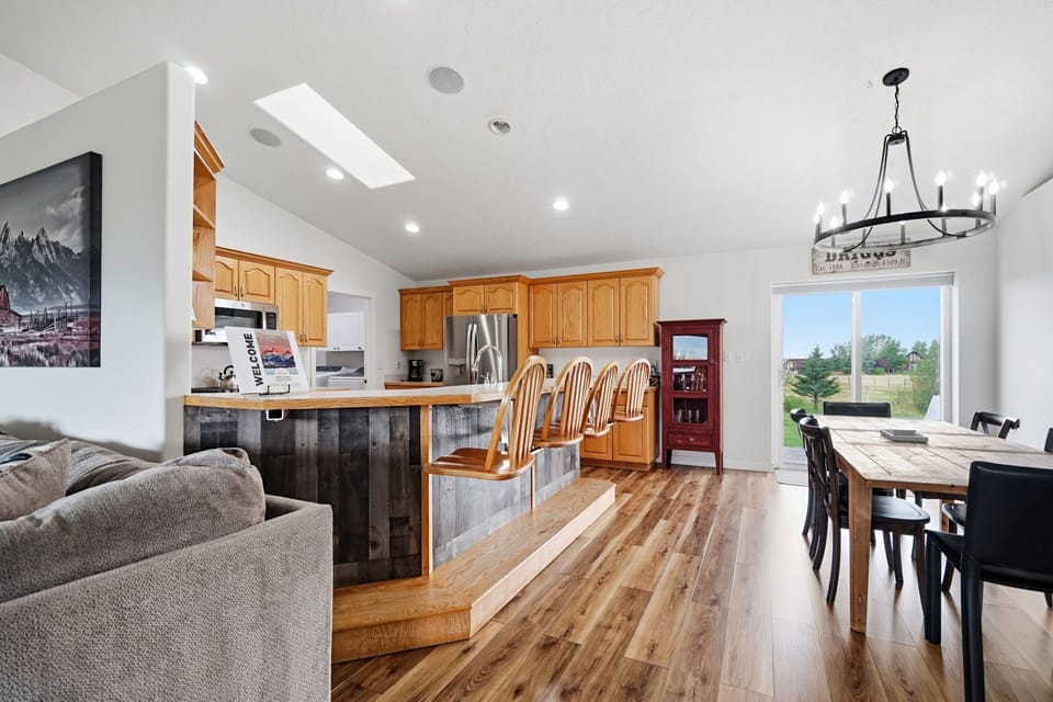 Bright open kitchen and dining area with bar seating and outdoor views