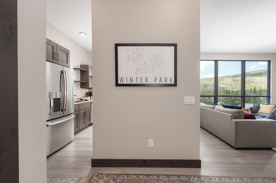 - Wall art with Winter Park design adds local touch   - Hallway connects open kitchen to bright living area   - Modern layout with mountain inspired details