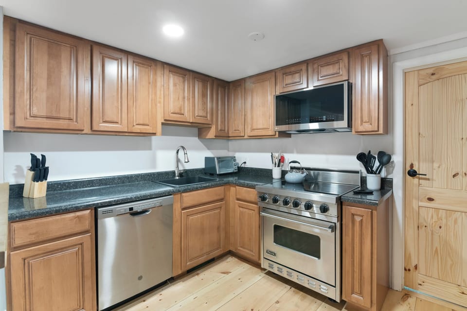 Main level kitchen with stainless steel appliances and stocked with essentials