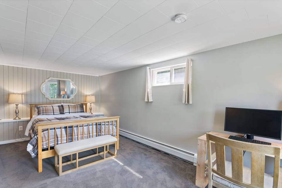 Lower level bedroom with a queen bed and dedicated workspace