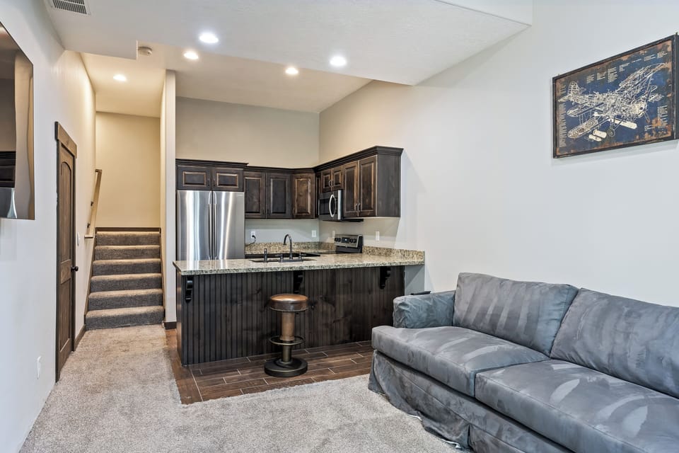 - Lower level kitchenette with granite counters  
- Stainless steel appliances and dark cabinetry  
- Comfortable sofa seating perfect for relaxing