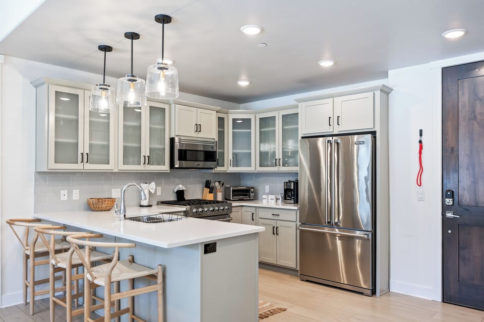 - Modern kitchen with stainless steel appliances  
- Bright countertops and spacious bar seating  
- Park City vacation rental fully equipped kitchen