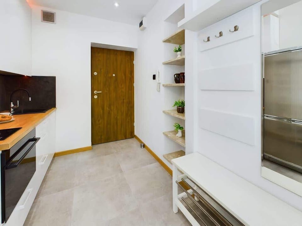 A bright and tidy hallway with tiled flooring and light-colored walls, leading into the main living area.