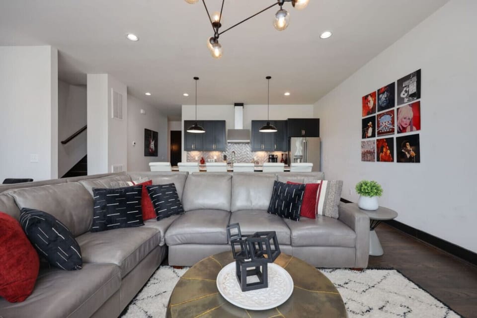 Stylish open-plan living space with a grey sectional and track lighting.