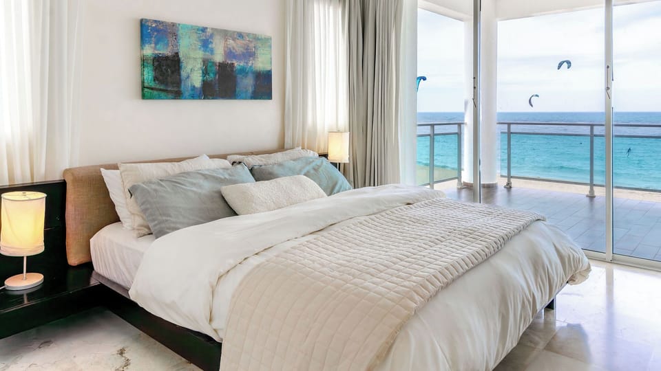 Wake up to endless blue and fall asleep with the sound of the waves. A serene oceanfront bedroom designed for rest, light, and total relaxation.