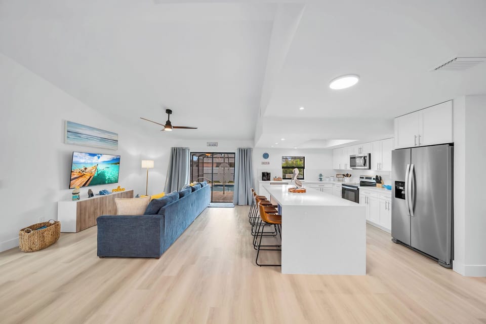 The modern open floor plan merges the TV area and kitchen for ultimate comfort.