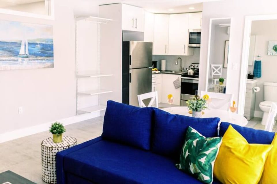 Step into relaxation in our inviting living room, where a plush couch and stylish center table beckon. Enhance your experience with a smart TV, a convenient side table, and a charming dining table for three.