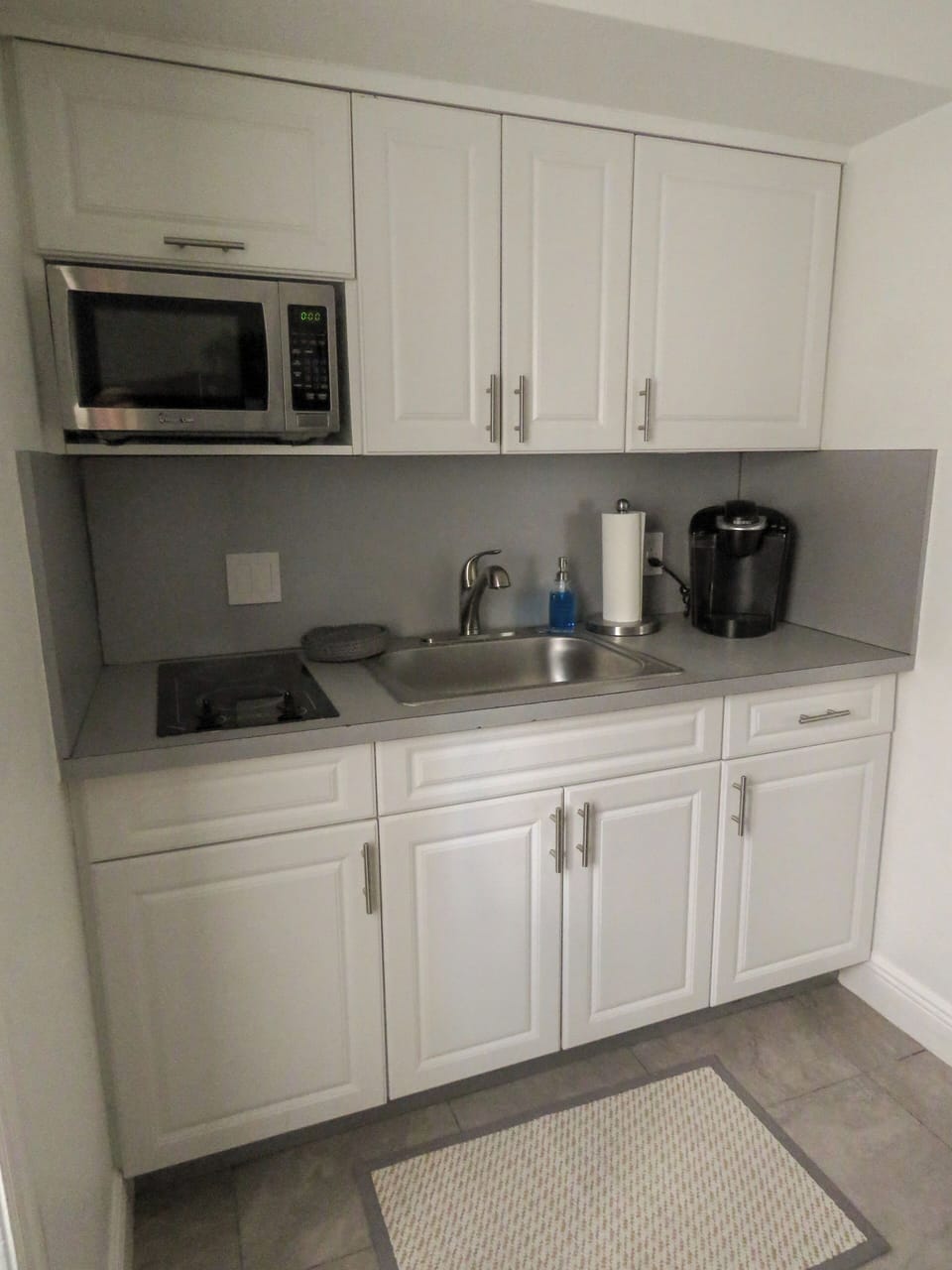 Fully stocked kitchen with a two-stove burner, microwave and Keurig