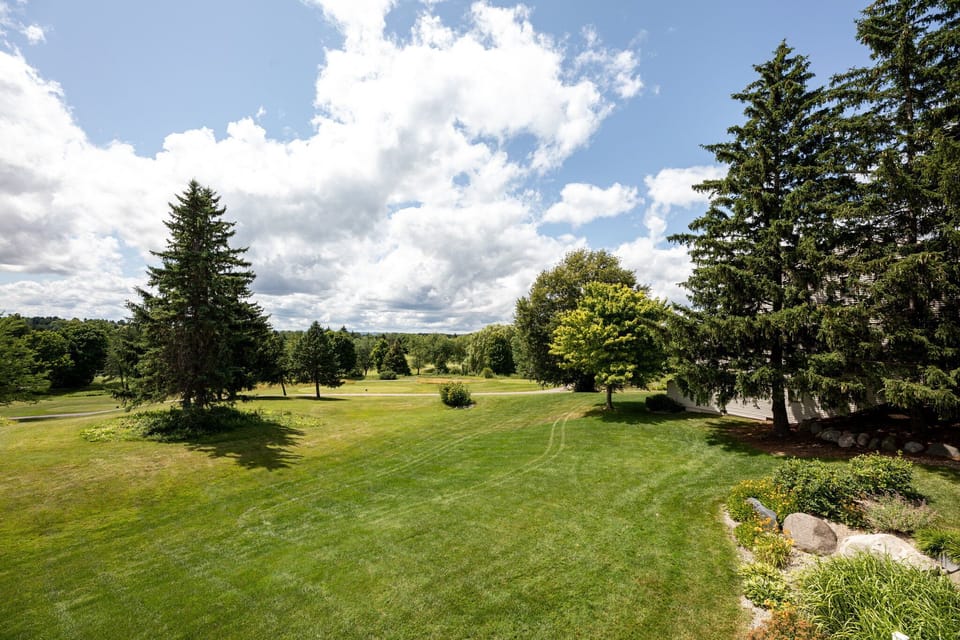 Open green fairways under wide blue skies, perfect for a scenic stroll.