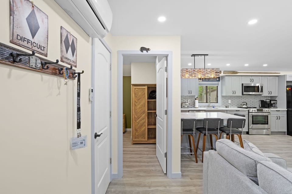 This inviting space seamlessly connects the living room, kitchen, and hallway, creating a spacious yet cozy atmosphere. The warm tones and stylish accents make it feel just like home.