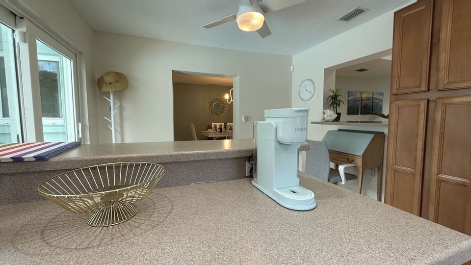 Fully-equipped kitchen w/ breakfast bar w/ 2 bar stools and direct pool access.
