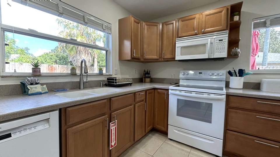Fully-equipped kitchen w/ breakfast bar w/ 2 bar stools and direct pool access.