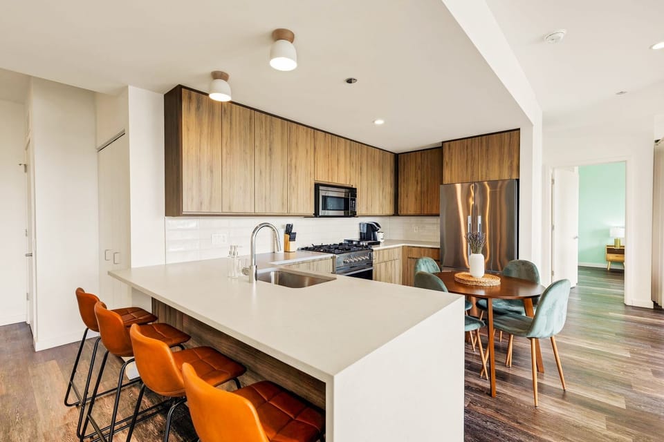 Modern Kitchen with Breakfast Bar, Dining Area, and Elegant Wood Finishes
