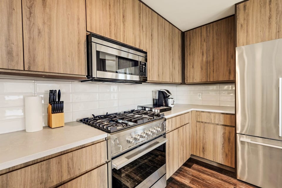 Modern Kitchen with Breakfast Bar, Dining Area, and Elegant Wood Finishes