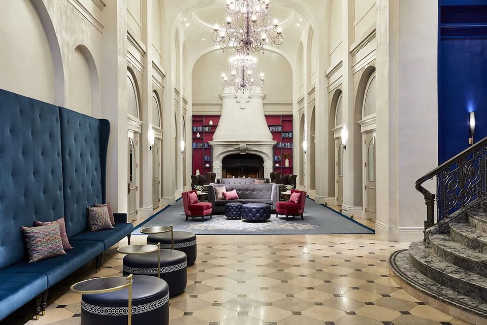 Step into a grand lobby beneath sparkling chandeliers and arches.