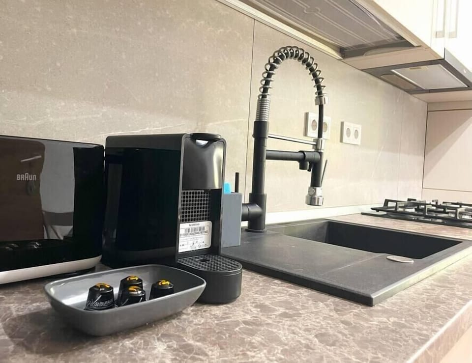 Fully equipped kitchen with huge fridge with freezer that has a water dispenser incorporated, stove, oven, toaster, coffee maker, cutlery, basic condiments and dining table