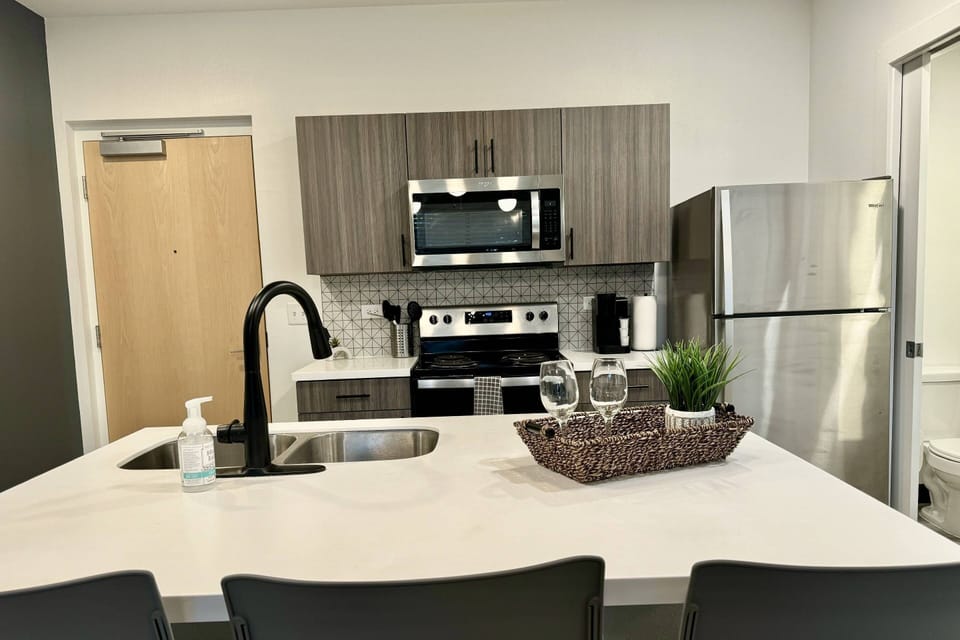 Modern kitchen with stainless steel appliances, spacious island, and stylish touches-perfect for entertaining!