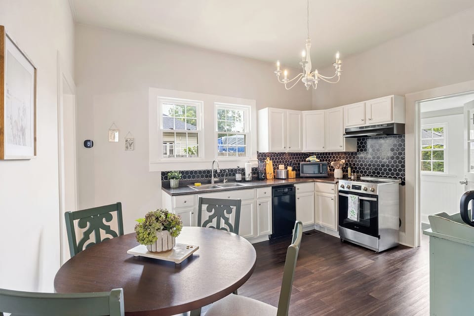 Fully stocked kitchen with modern stainless steel stove and cookware