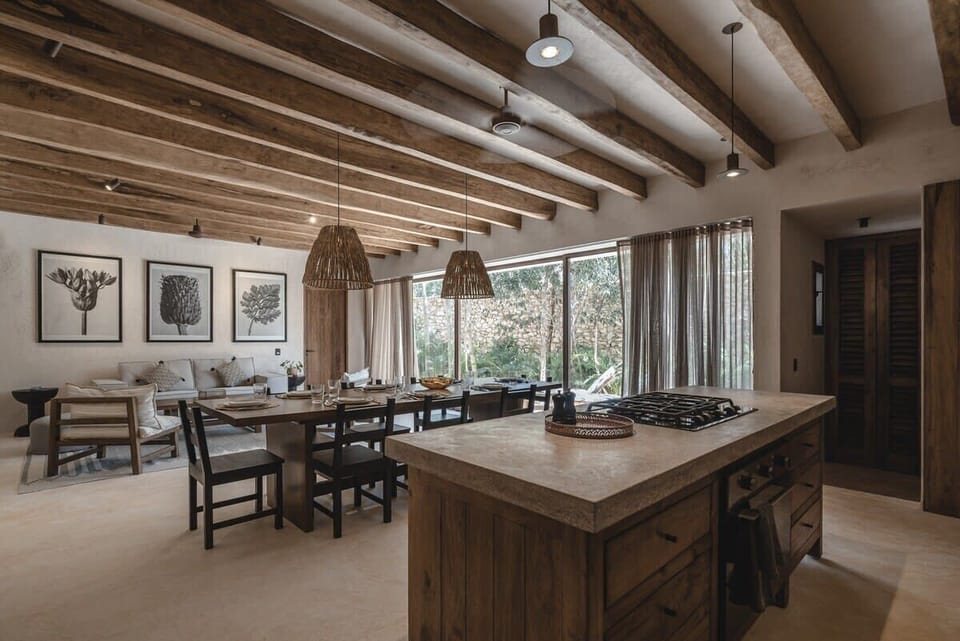 Kitchen, dining area and living area accompanied by floor-to-ceiling windows looking out to the private garden
