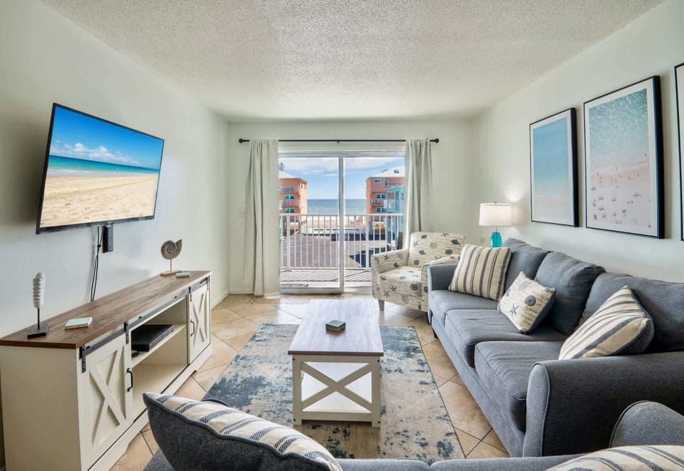 Bright open living space with comfy sofa, Smart Tv, and balcony