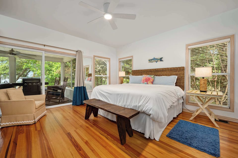A primary suite fit for a king, this bedroom opens up to a private screened-in porch. 