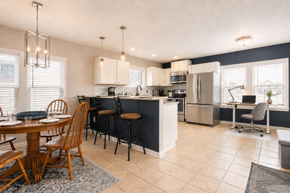 Bright open kitchen with island seating, dining area, and workspace