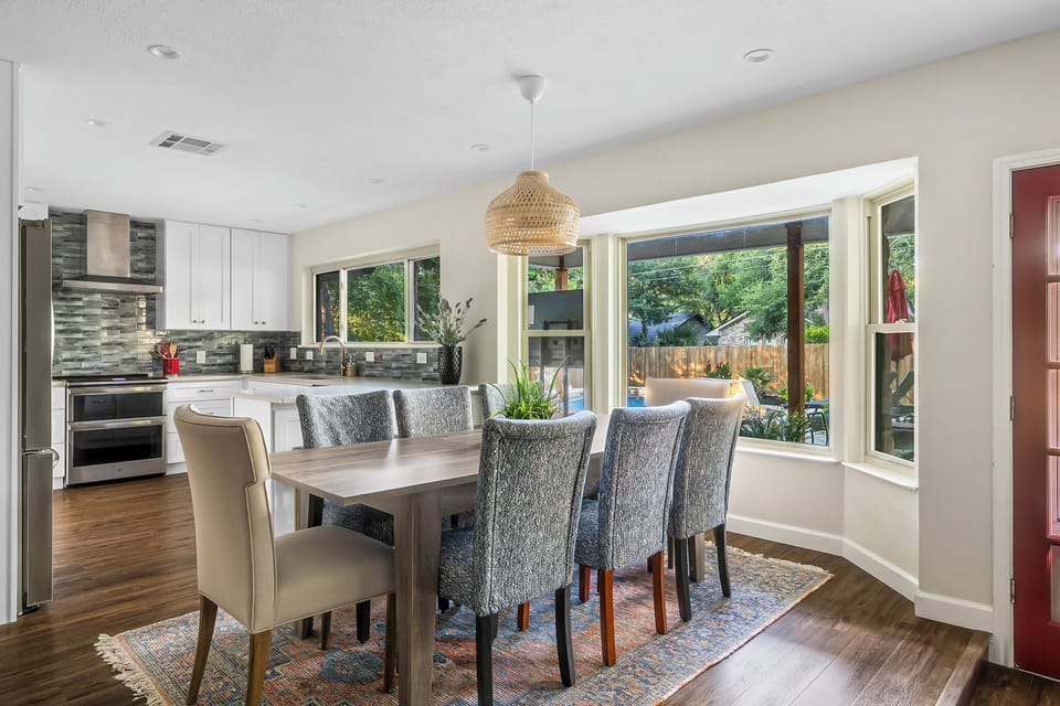 Our dining table has 8 chairs and is near a window to a beautiful view while enjoying a meal.