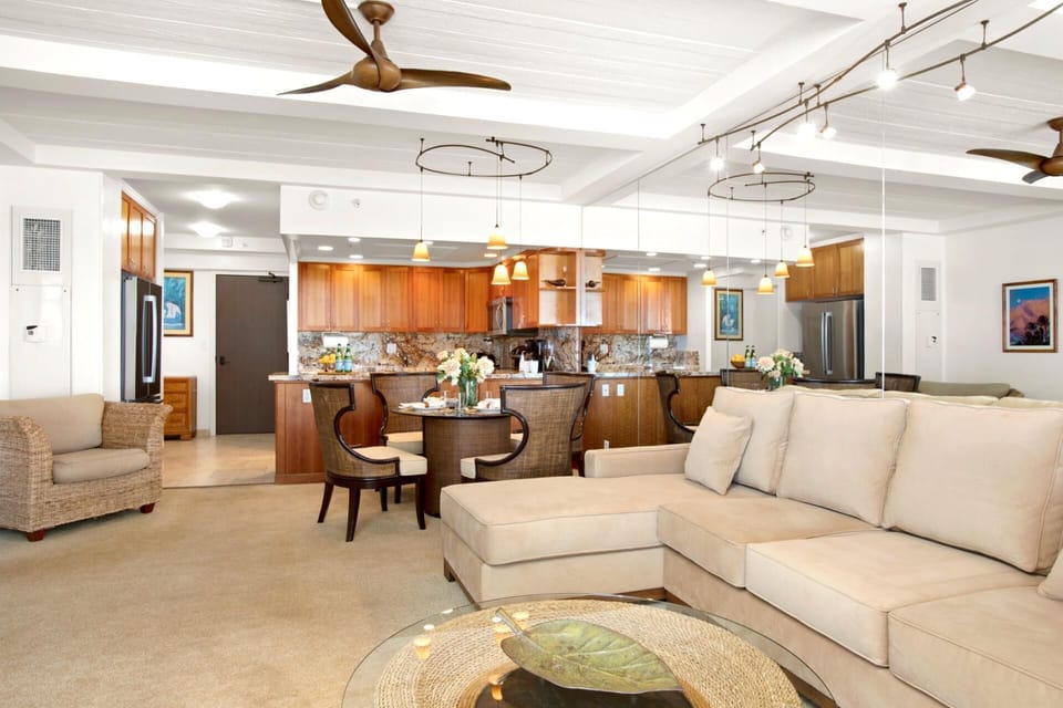  Polished and serene, this open-concept haven pairs a luxe sectional and tropical wood finishes with warm, ambient lighting—perfect for sharing meals, memories, and island moment   