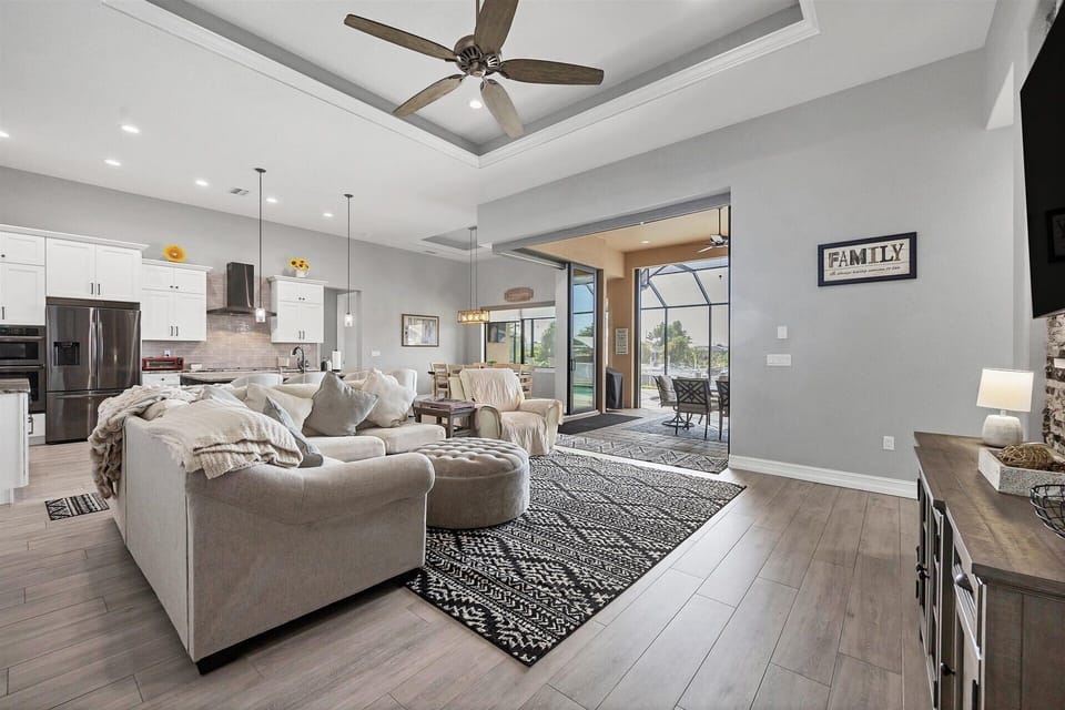 Large living room with view of the canal. Living room features comfy, ample seating and 85-inch Smart TV