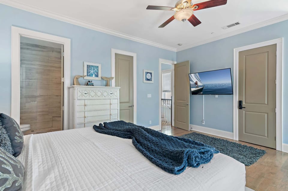 this serene bedroom with a comfortable king bed and a TV