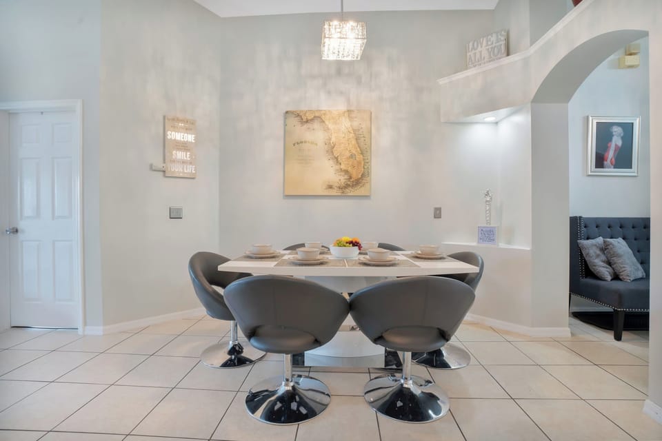 Modern dining area with a sleek table and comfortable swivel chairs under a stylish pendant light.