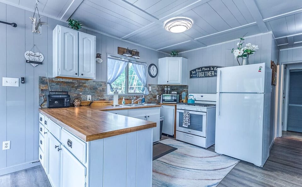 The full kitchen is equipped with everything you need for a delightful culinary experience, including a coffee maker, barbecue utensils, dishes and cutlery, cooking basics, a freezer, kettle, microwave, oven, fridge, stove, and toaster.