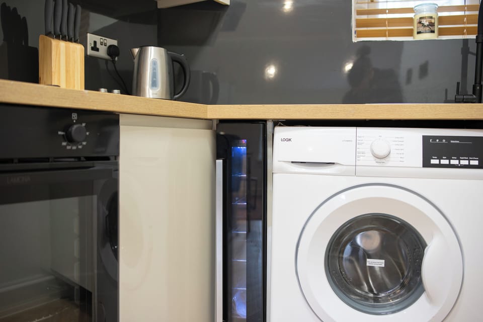 A spacious open-plan kitchen equipped with modern appliances and a washing machine—perfect for longer stays.