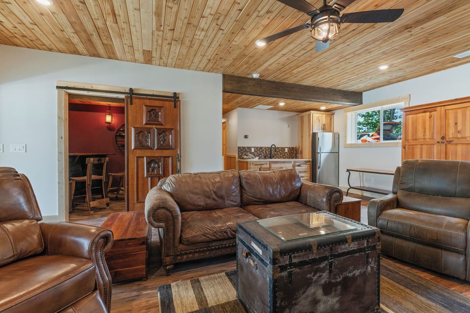Lower-level game room w gas fireplace, TV, shuffleboard & kitchenette