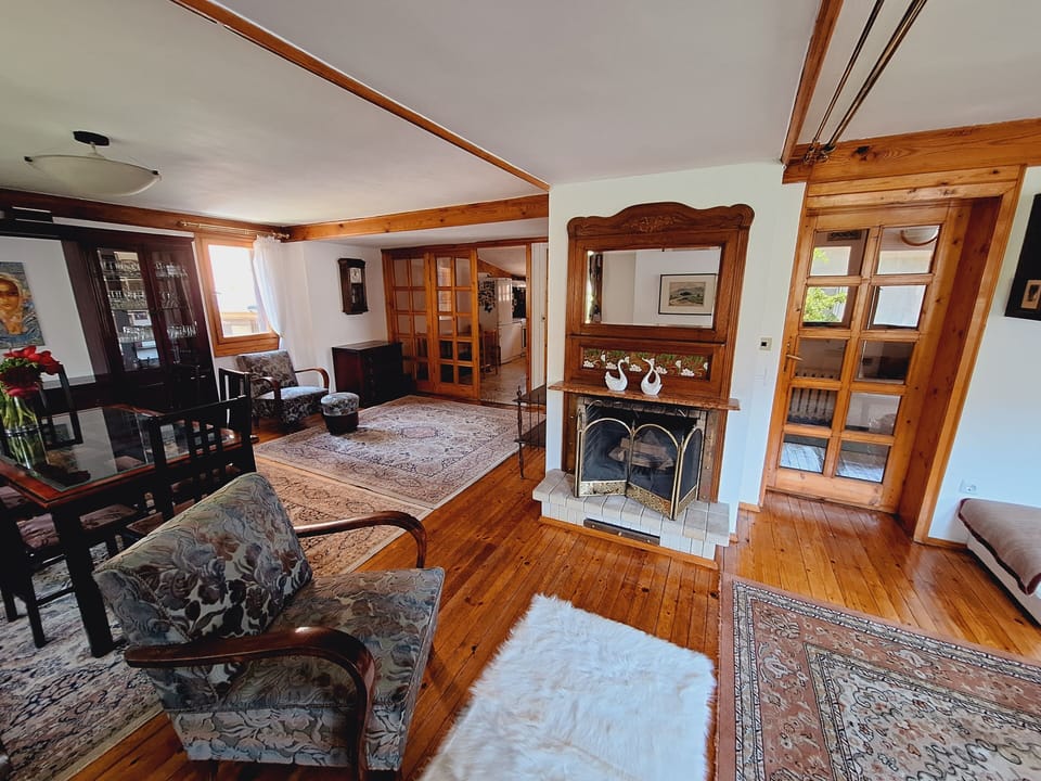 Spacious open-concept living & dining room space with decorative fireplace.