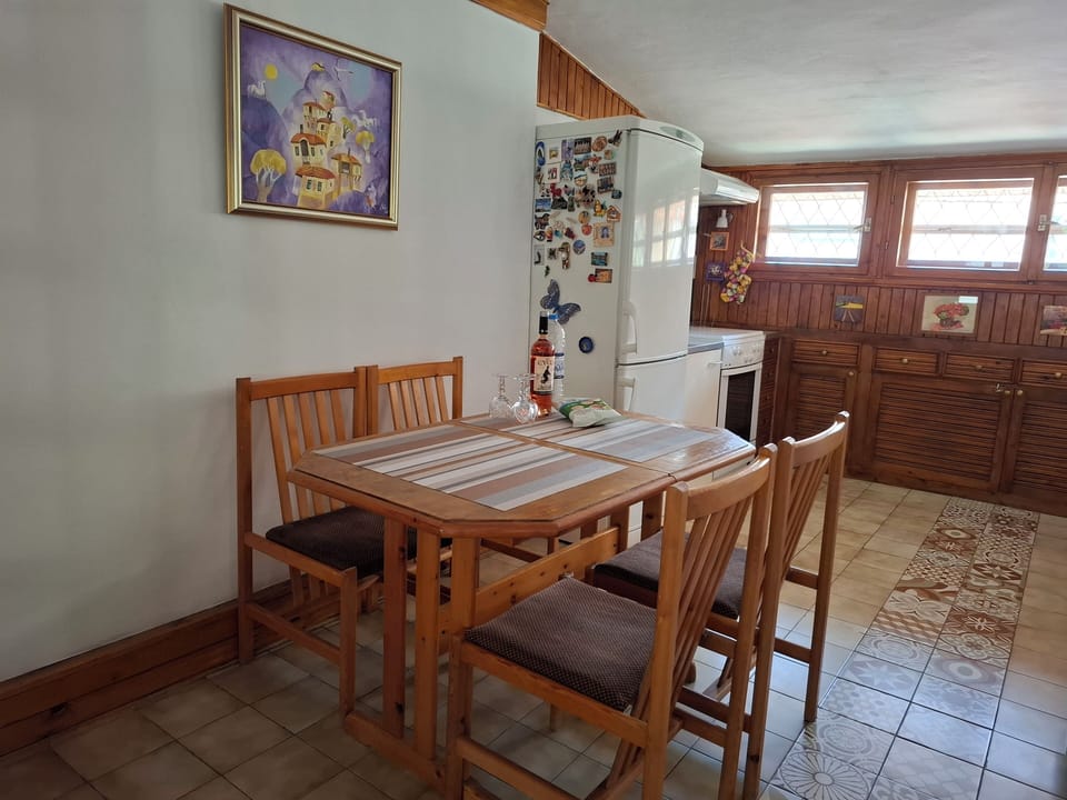 Entrance to the L-shaped kitchen, with an extendable wooden table and tile floor