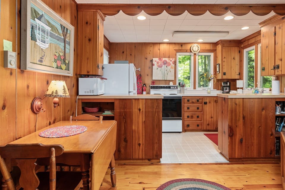Bright kitchen w/ wood cabinetry, breakfast bar, and open flow to dining area.