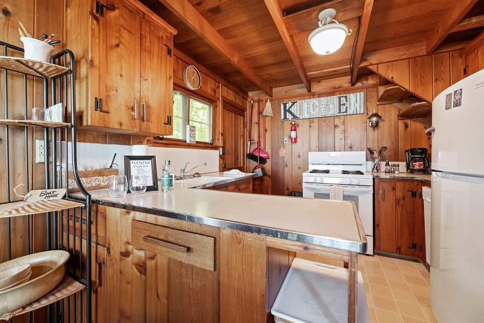 Rustic kitchen w/ wood cabinetry and breakfast bar for easy meals together.