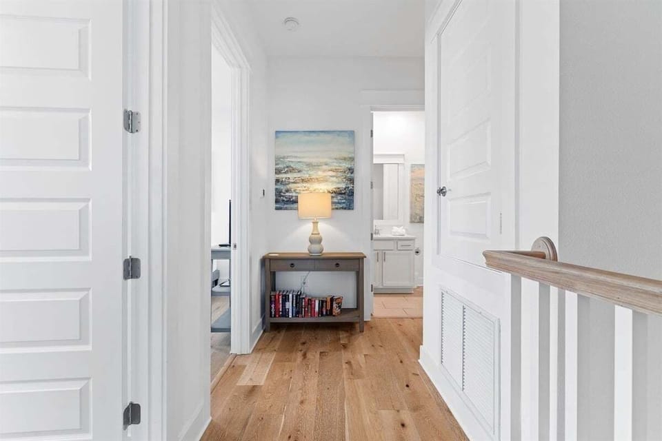 This bright and airy hallway features a beautifully curated bookshelf, adding charm and functionality.