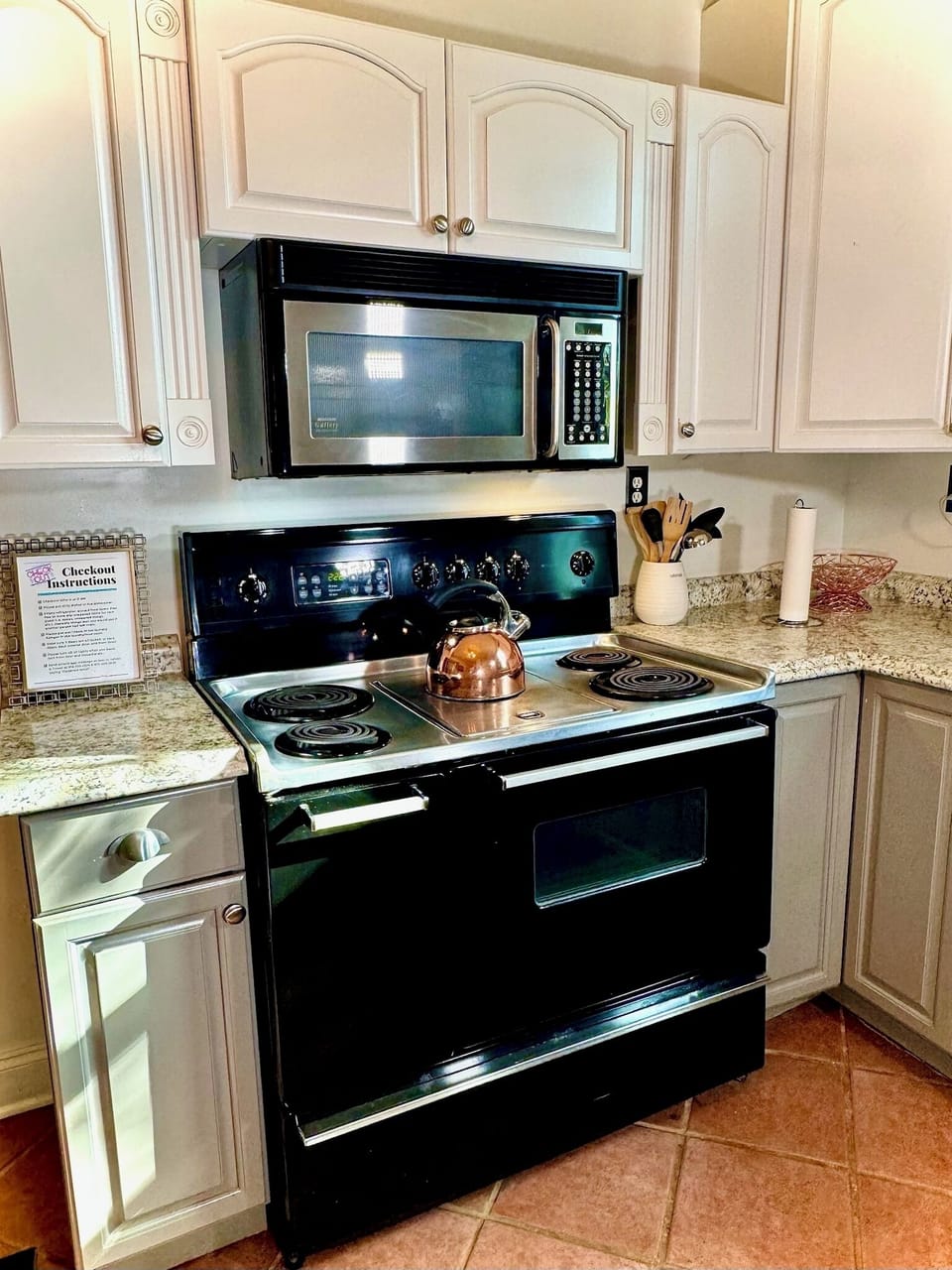 Kitchen with vintage stove, griddle & microwave—ideal for easy meals.